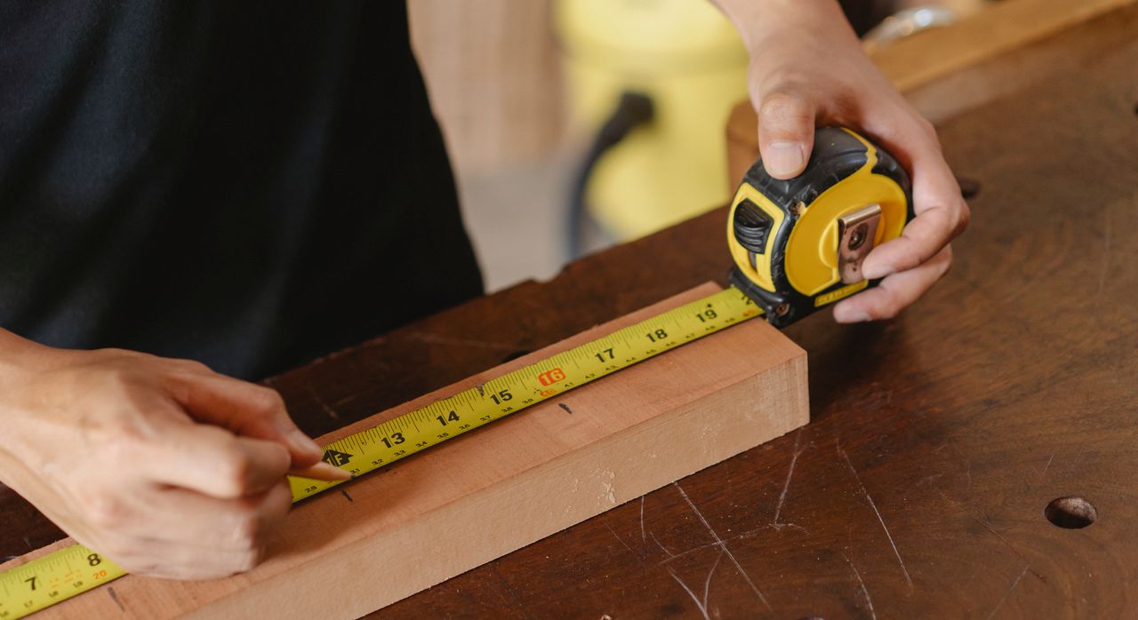 The Art of Drawing Readers In: Your attractive post title goes here Accurate unrecognizable male worker with pencil and measuring tape on wooden board standing near workbench during work process on blurred background