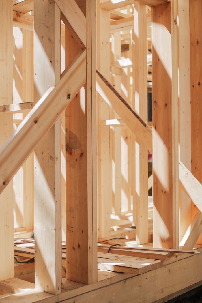 Mastering the First Impression: Your intriguing post title goes here Close-up of wooden beams and framework in construction site, bathed in sunlight.